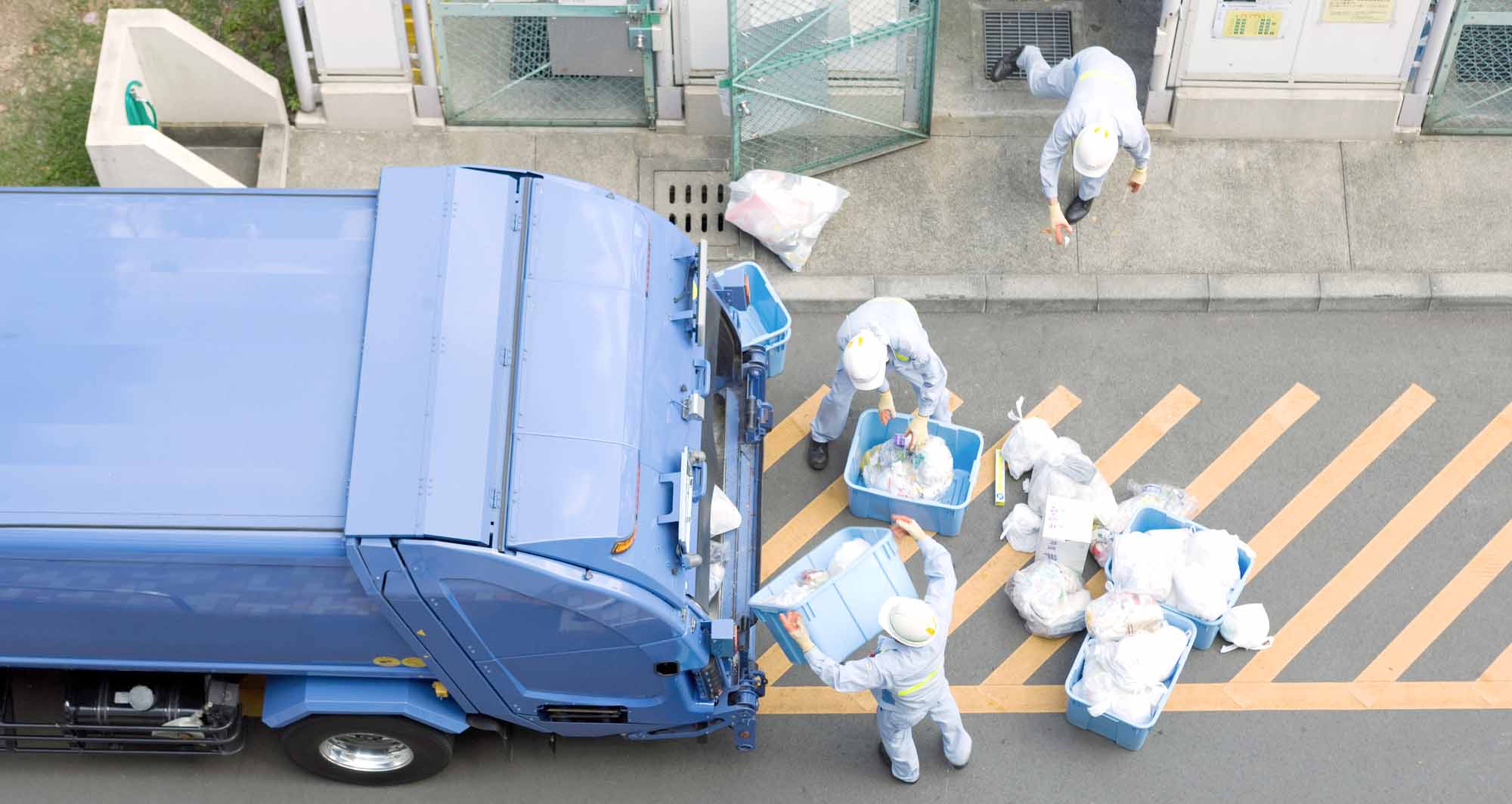 ごみ収集車と、収集作業を行う作業員